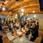 Degustazione guidata in una sala con travi in legno durante un evento aziendale