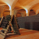 Cantina storica con bottiglie di vino dell'Oltrepò Pavese in affinamento