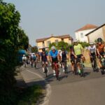 Gruppo in bicicletta su strada collinare – team building cicloturistico in Oltrepò Pavese