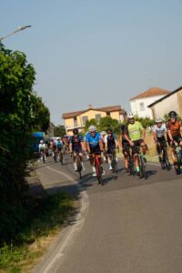 Gruppo in bicicletta su strada collinare – team building cicloturistico in Oltrepò Pavese