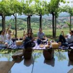 Picnic di gruppo sotto la pergola di un vigneto – team building informale in Oltrepò Pavese